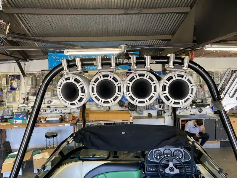 Four tower speakers mounted on a wake boat tower in the shop